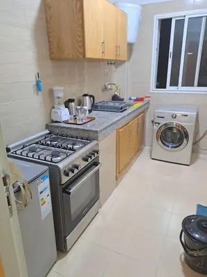 a kitchen with a stove and a washing machine at très joli appartement vue sur mer présentation acte de mariage si couple in Rabat