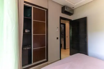 a bedroom with a closet with a glass door at L Évasion ZEN Duplex d Exception Entre Plage et Serenite in Mohammedia