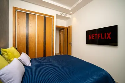 a bedroom with a bed with a netflix sign on the wall at Welcome to Casa Luxe 3 King Beds Near CFC & Tram in Casablanca