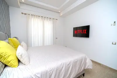 a bedroom with a white bed with yellow pillows at Welcome to Casa Luxe 3 King Beds Near CFC & Tram in Casablanca