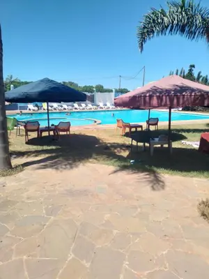 a group of tables and chairs next to a pool at Havre de paix à TAMARIS in Dar Mohammed Ould Haj Jilali