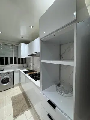 a kitchen with white cabinets and a refrigerator at Well-equipped luxury apartment in Temara