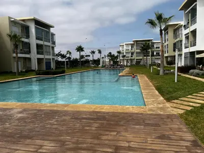 a swimming pool in front of some apartment buildings at Appartement de vacances CASABAY Sidi Rehal in Sidi Rahal
