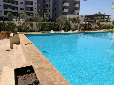 a large blue swimming pool in a building at Duplex Zenata Tower in Aïn Harrouda