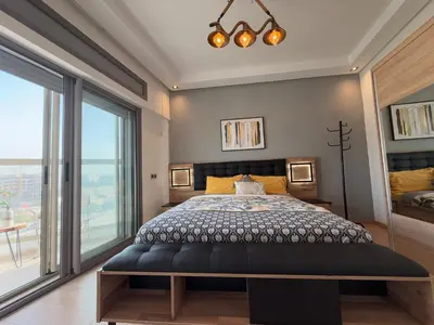 a bedroom with a bed and a large window at Cosy and sunny - private Rooftop - near train & tramway in Casablanca