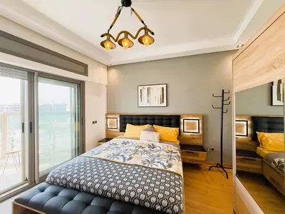 a bedroom with a bed and a large window at Cosy and sunny - private Rooftop - near train & tramway in Casablanca