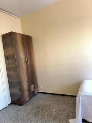 a bedroom with a wooden cabinet next to a bed at Chambre cosy au cœur de Rabat in Rabat
