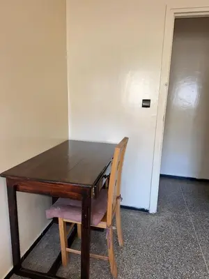 a wooden table with a wooden chair in a room at Chambre cosy au cœur de Rabat in Rabat