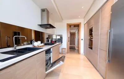 a kitchen with a sink and a refrigerator at Appartment De Lux a California in Bali Luxury Residence in Casablanca