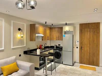 a kitchen with a refrigerator and a table at C39 1BR Studio - Cozy & Central in Maarif in Casablanca