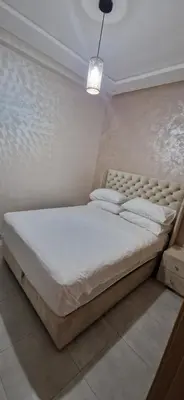 a bedroom with a large bed with white sheets and pillows at Cozy Guesthouse, Ain Sebaa, Casablanca in Casablanca