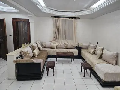 a living room with a couch and a table at Appartement ensoleillé de 100 m2 à Mohammedia à 10 mn de la mer in Mohammedia