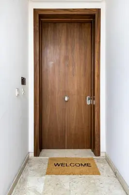 a wooden door with a welcome mat in front of it at TT holidays Casa Oasis in Casablanca