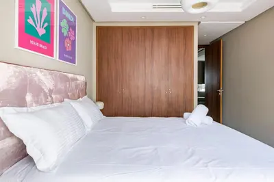 a bedroom with a white bed with a wooden door at TT holidays Casa Oasis in Casablanca