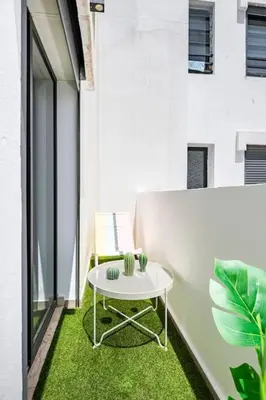 a small white table on a balcony with green grass at TT holidays Casa Oasis in Casablanca
