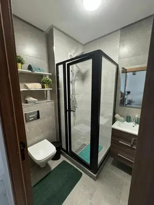 a bathroom with a shower and a toilet and a sink at Résidence Natura Living au parc in Mohammedia