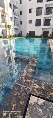 a swimming pool in front of a building at Studio cosy in Nouaceur