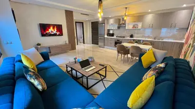 a living room with a blue couch and a kitchen at D2 L'Art de Vivre Urbain au Cœur de Casablanca maarif in Casablanca