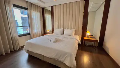a bedroom with a large white bed with two lamps at D2 L'Art de Vivre Urbain au Cœur de Casablanca maarif in Casablanca
