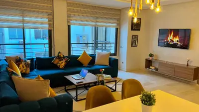 a living room with a blue couch and a fireplace at D2 L'Art de Vivre Urbain au Cœur de Casablanca maarif in Casablanca