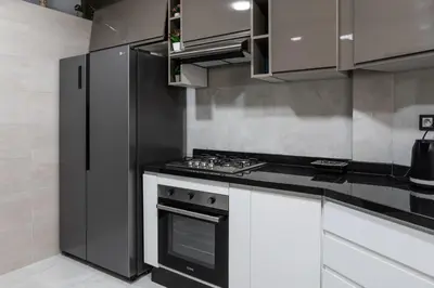 a kitchen with white cabinets and a stove top oven at Joli appartement 2 chambres in Casablanca