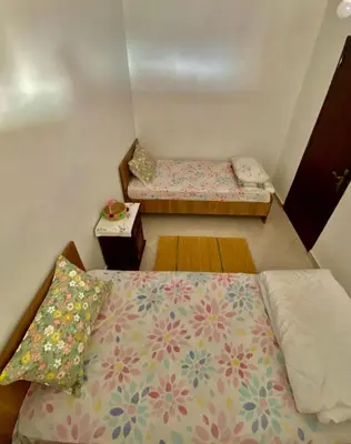 a small room with two beds and a table at Confort Moderne à 2 Pas de la Mer Calme Absolu in Dar Bouazza