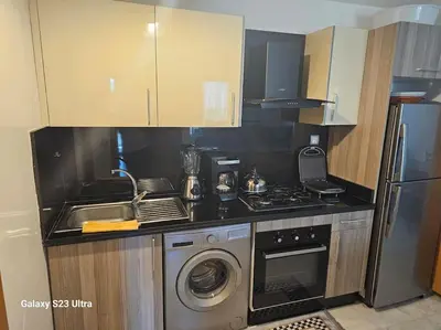 a kitchen with a sink and a stove and a dishwasher at Studio a Mohammedia pied dans l'eau in Mohammedia