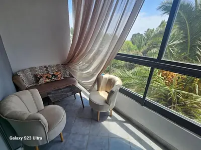 a living room with two chairs and a window at Studio a Mohammedia pied dans l'eau in Mohammedia