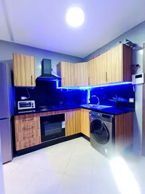 a blue kitchen with a washer and a dishwasher at Beachside Apartment in Mohammedia