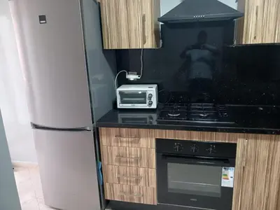 a kitchen with a refrigerator and a stove and a microwave at Beachside Apartment in Mohammedia