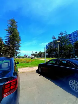two cars parked in a parking lot in a park at Beachside Apartment in Mohammedia