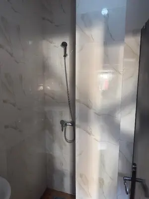 a shower in a bathroom with a marble wall at chic chambre meublée in Casablanca
