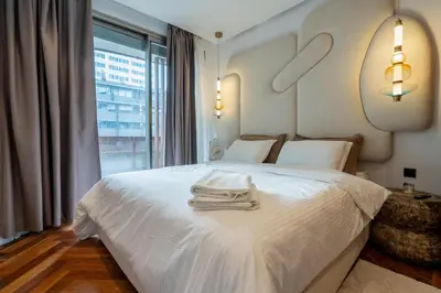 a bedroom with a white bed and a large window at Élégance Urbaine Casa Finance city in LʼOasis
