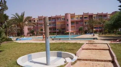 a large apartment building with a pool and a pole at Sahara beach Mansouria in Mansouria