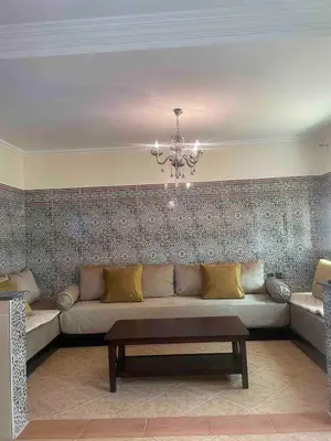 a living room with a couch and a chandelier at Sahara beach Mansouria in Mansouria