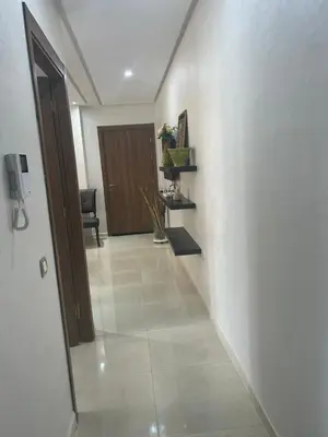 a hallway with a door and a tiled floor at Appartement location in Bouznika