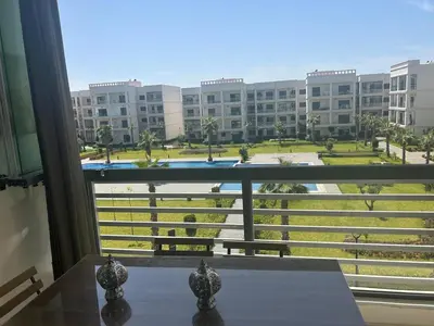 a view of a large building from a window at Appartement location in Bouznika