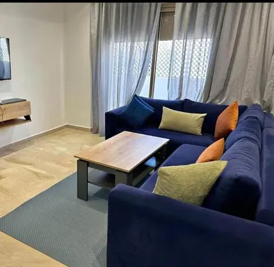 a living room with a blue couch and a coffee table at Studio charme à prix doux in Casablanca