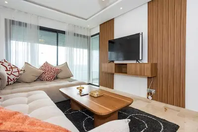 a living room with a couch and a tv at Appartement Royal in Beni Brour