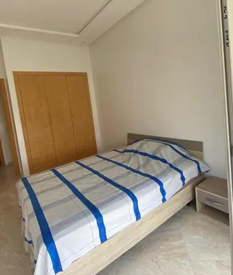 a bedroom with a bed with blue and white sheets at Casabay sidirehal in Sidi Rahal