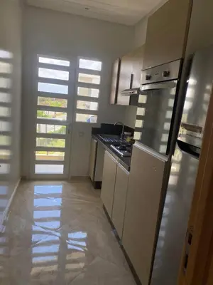 a kitchen with white cabinets and a stove top oven at Casabay sidirehal in Sidi Rahal