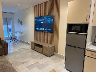a living room with a flat screen tv on a wall at Residence le 11 in Casablanca