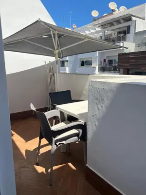 a table and chairs on a balcony with an umbrella at Residence le 11 in Casablanca