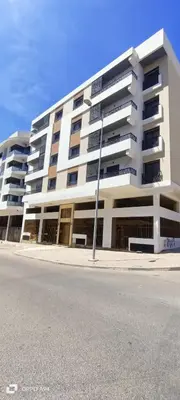 a large white building on the side of a street at La résidence de Palais in Bouskoura