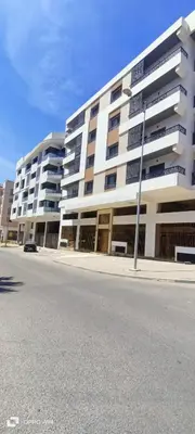 a large white building on the side of a street at La résidence de Palais in Bouskoura