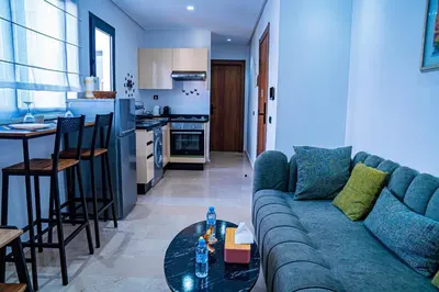a living room with a blue couch and a kitchen at R102- Stylish and Functional 1 BR Apartment at the center of Belvedere in Casablanca