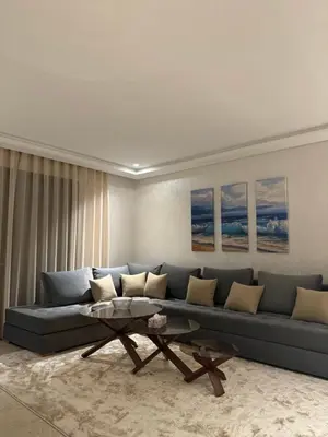 a living room with a blue couch and a coffee table at Appartement de prestige à Casablanca in Casablanca