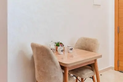 a wooden table with two chairs and two cups at Casablanca Centre Confort Luxe Emplacement idéal in Maarif