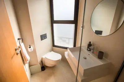 a bathroom with a toilet and a sink and a mirror at Haut Standing 2-Bedroom Apartment in Gauthier in Casablanca