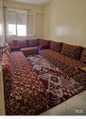 a living room with a couch with a large rug at Residence Louma in Mohammedia